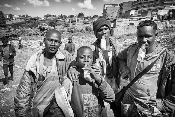 Each boy at the dump in Kenya has his own bottle of glue to snif